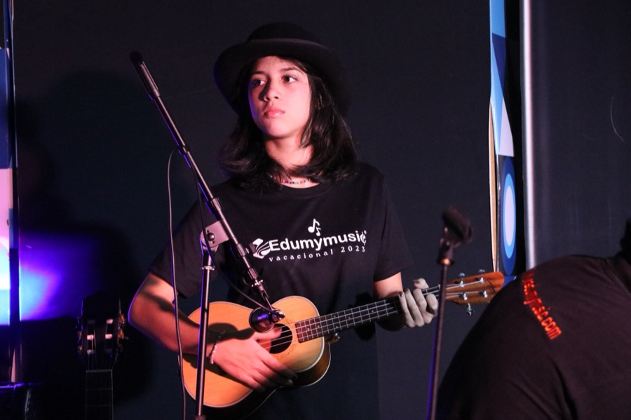 Alumna cantando y tocando el ukelele en el recital